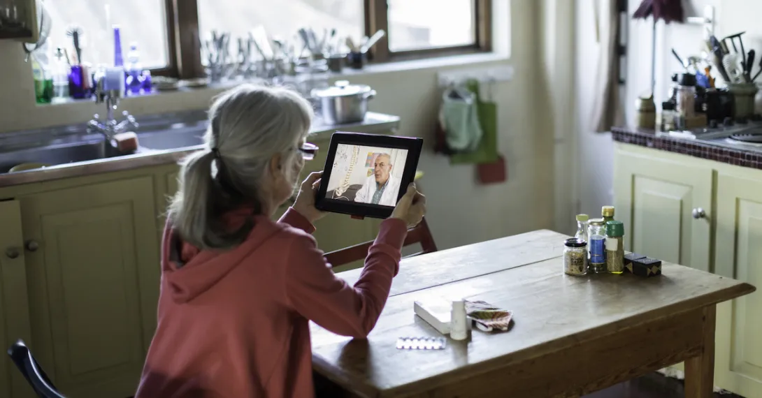An older person talking to a provider through a video chat on a tablet. An older person talking to a provider through a video chat on a tablet.