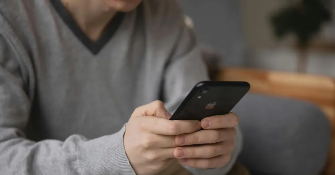 A person sitting in a couch using a smartphone A person sitting in a couch using a smartphone
