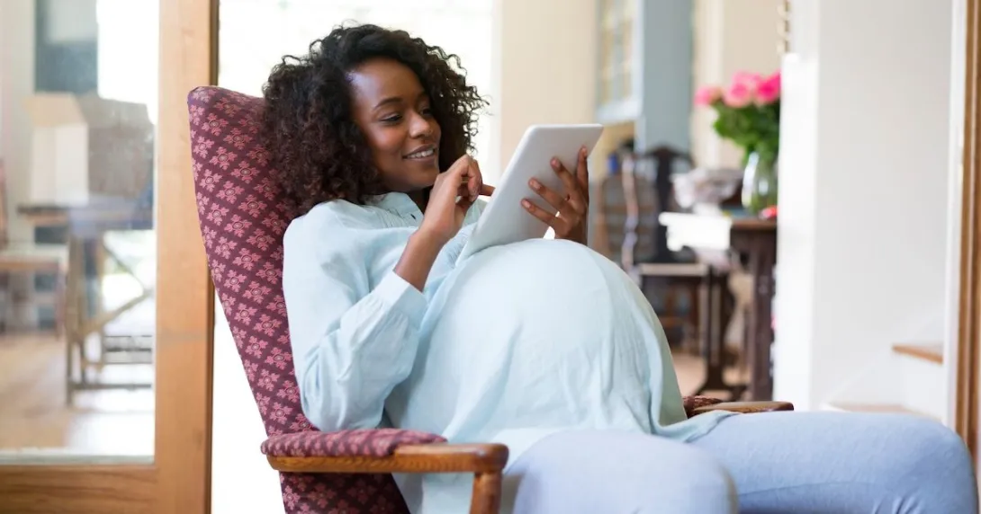 A pregnant woman using a tablet A pregnant woman using a tablet