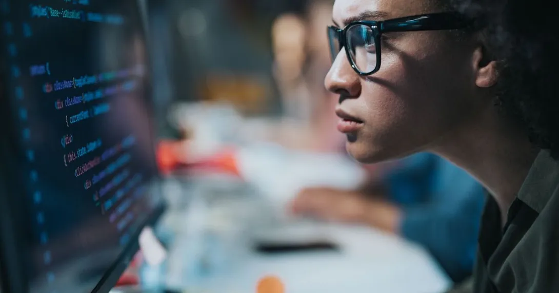 A focused programmer looking at her computer screen A focused programmer looking at her computer screen