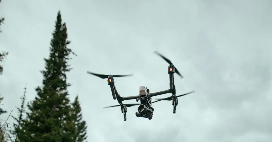A drone flying over a forest area A drone flying over a forest area