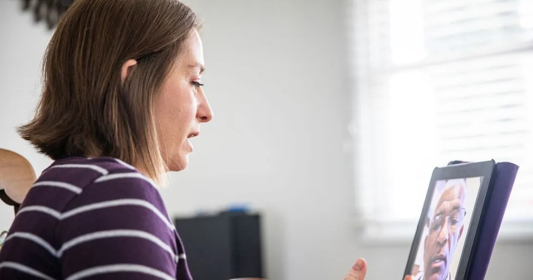 A woman talking to a provider through a video call on her tablet A woman talking to a provider through a video call on her tablet