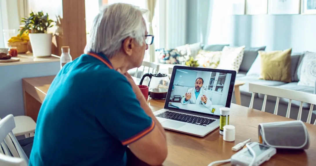 A person talking to a doctor via a video chat on his laptop. A person talking to a doctor via a video chat on his laptop.