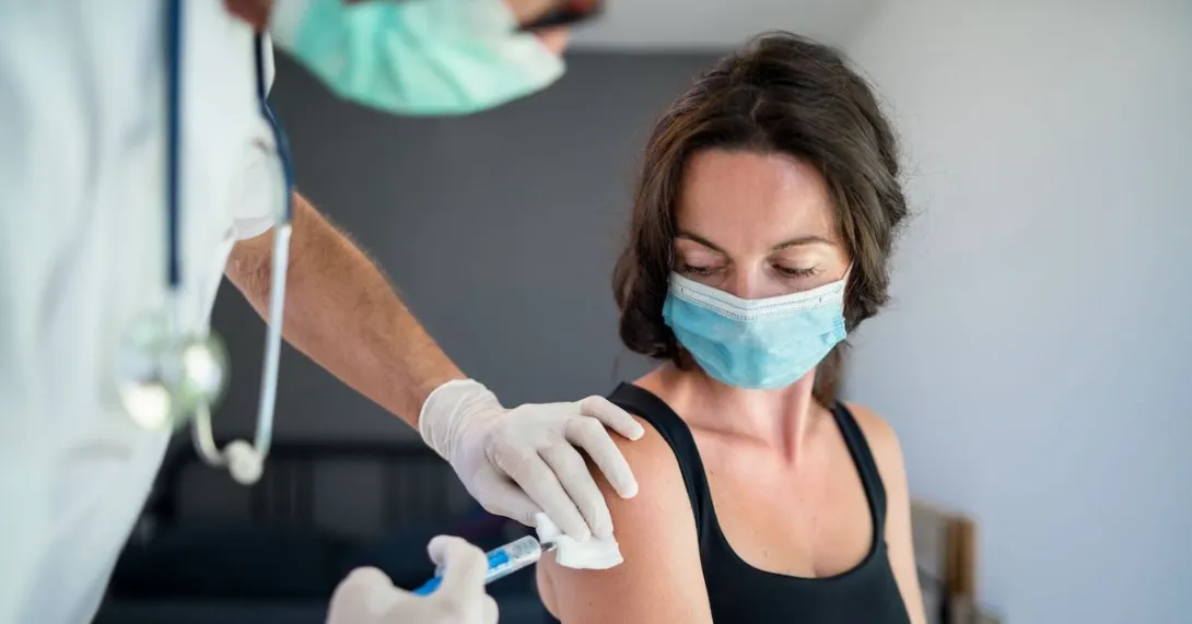 A woman receiving a vaccine. A woman receiving a vaccine.