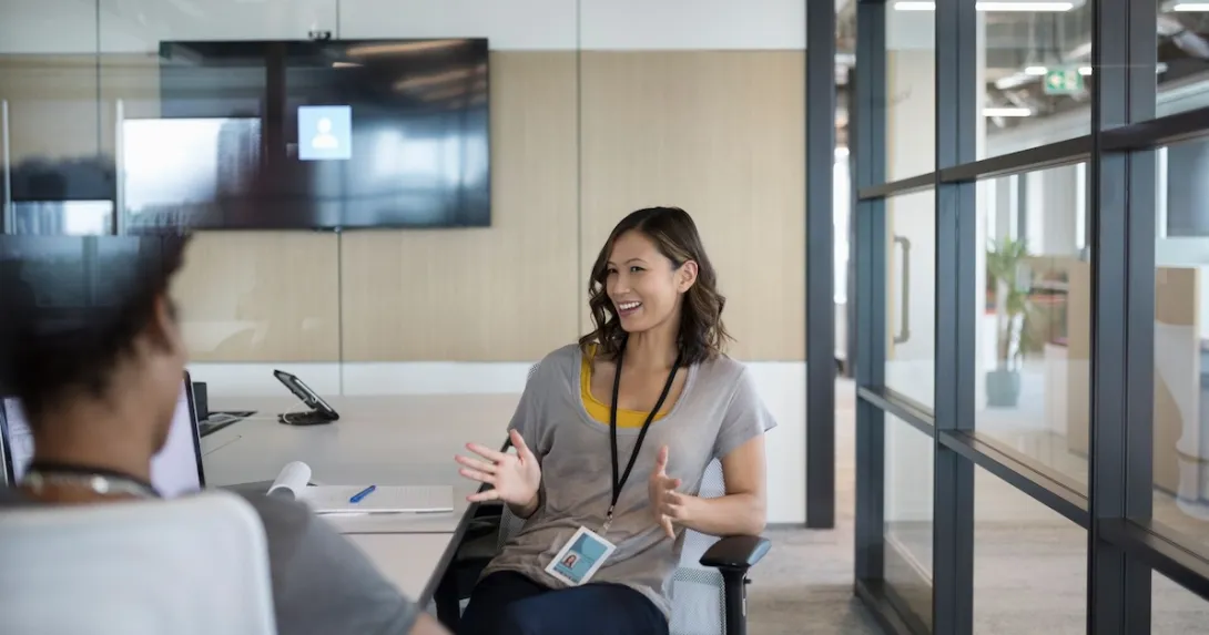 Two people sitting at a tablet talking to each other Two people sitting at a tablet talking to each other