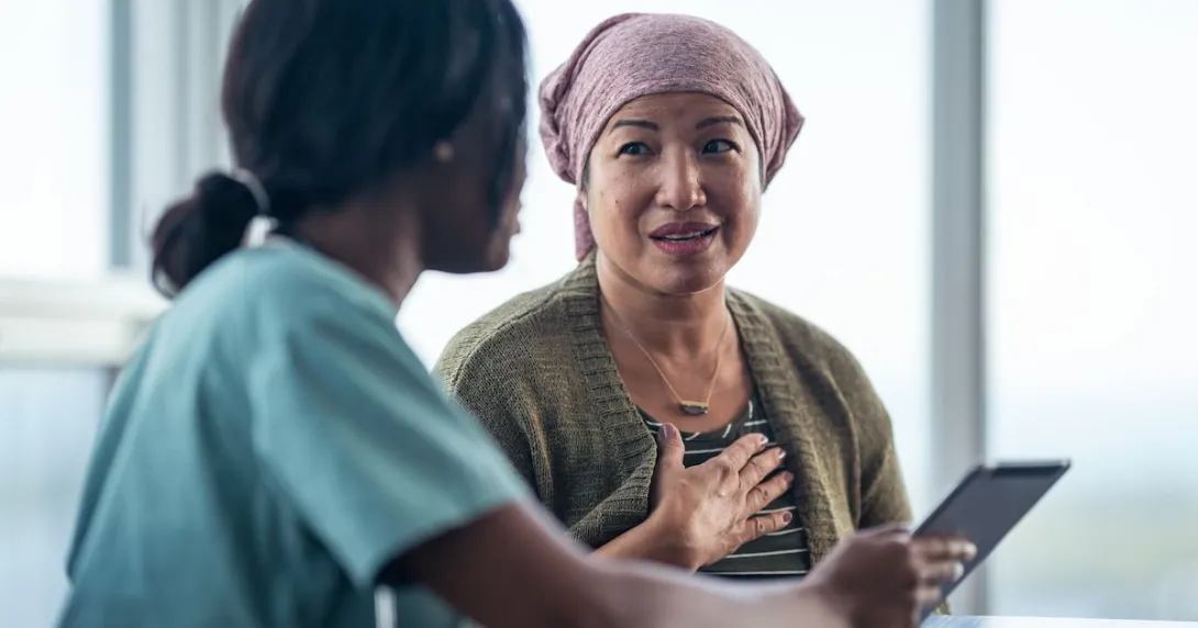 Healthcare provider talking to a patient while showing them a tablet Healthcare provider talking to a patient while showing them a tablet