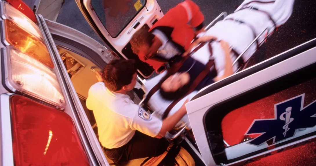EMTs bringing a patient into an ambulance on a stretcher EMTs bringing a patient into an ambulance on a stretcher
