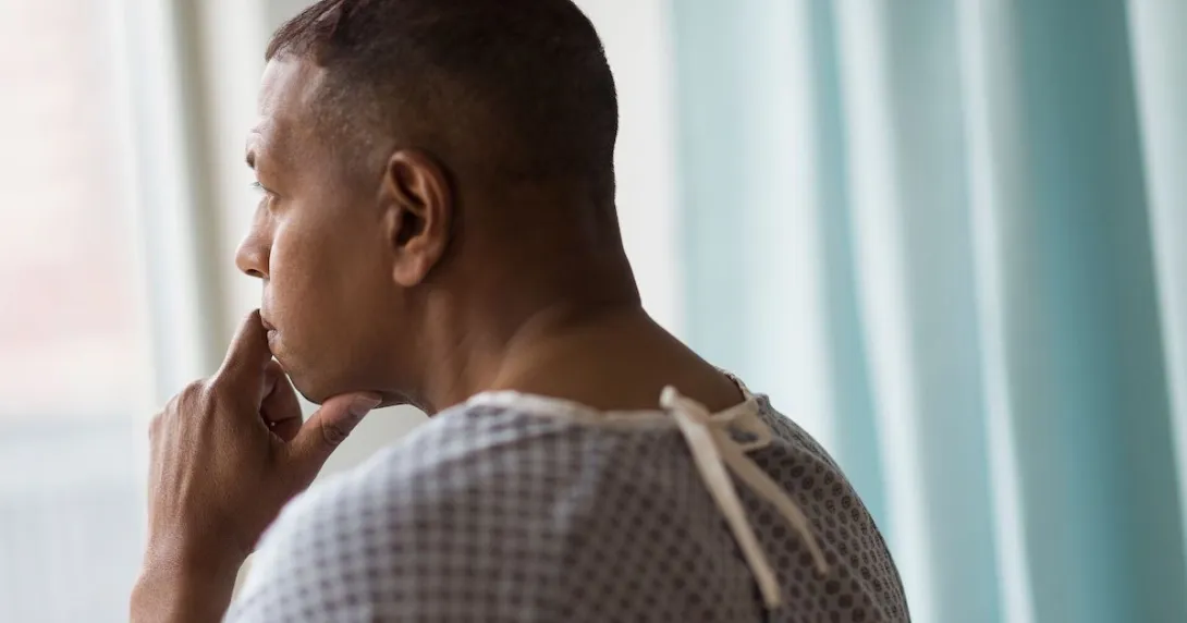 Person standing by a window looking out Person standing by a window looking out
