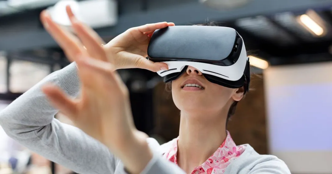 Person using a virtual reality headset while holding their hands up in front of them Person using a virtual reality headset while holding their hands up in front of them