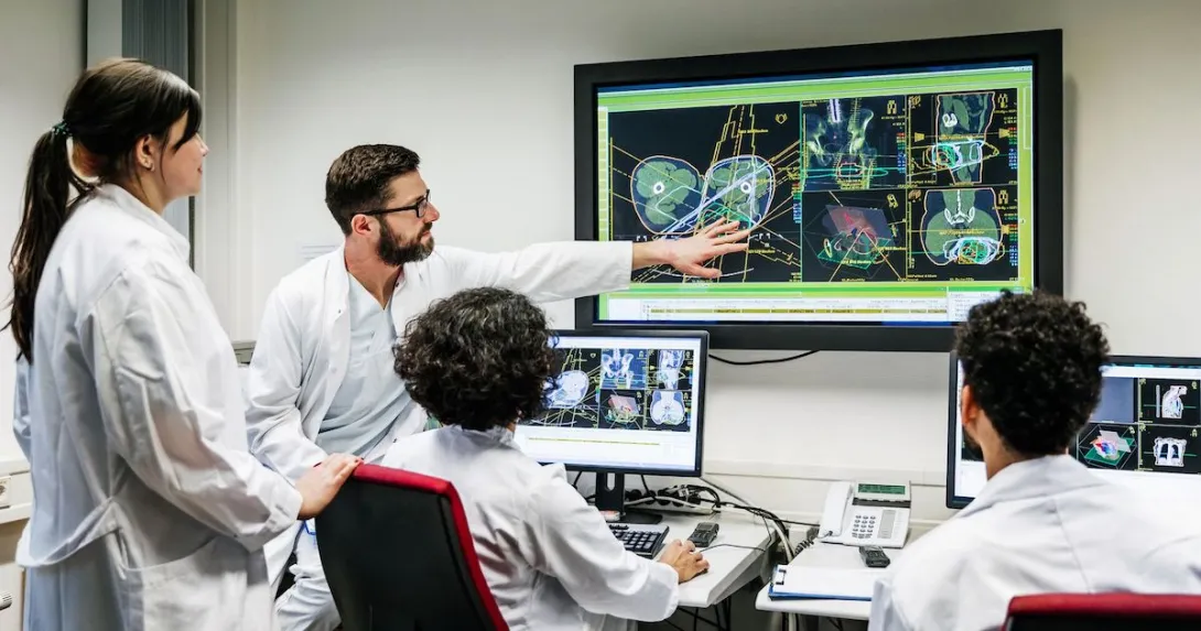 Healthcare providers sitting around a screen analyzing images Healthcare providers sitting around a screen analyzing images