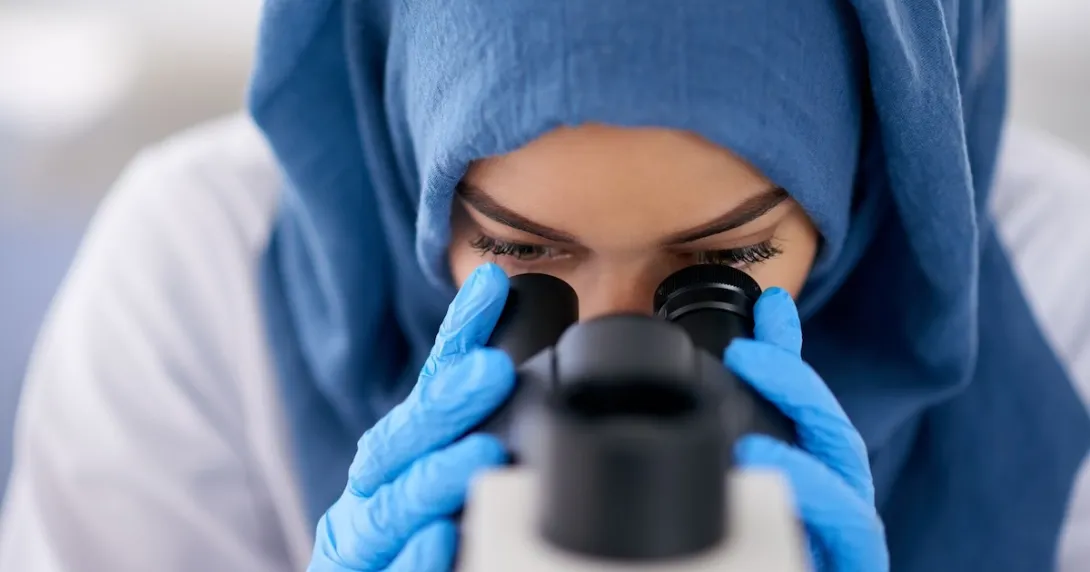Healthcare provider looking through a microscope Healthcare provider looking through a microscope