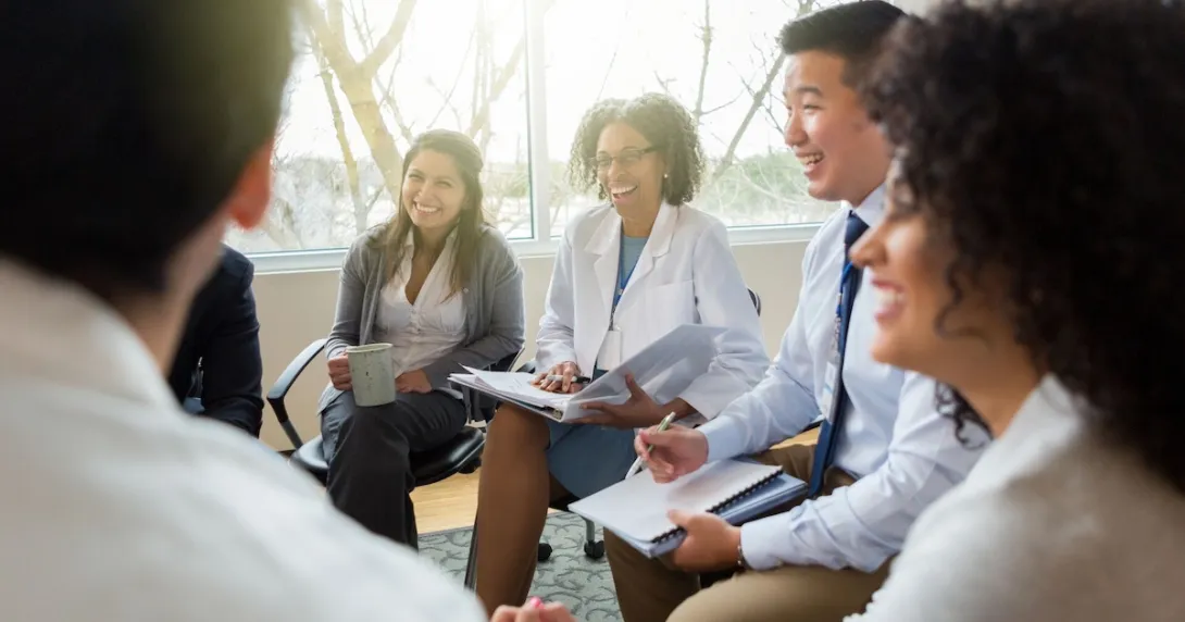 Five business people sitting on chairs in a circle Five business people sitting on chairs in a circle