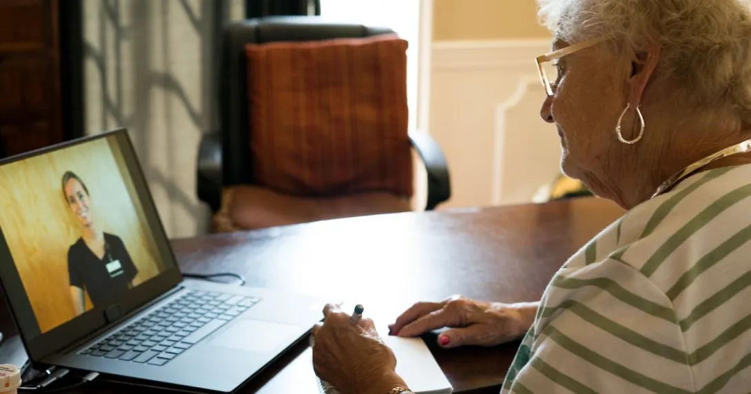 Person sitting in front of a computer while talking to a virtual healthcare provider Person sitting in front of a computer while talking to a virtual healthcare provider