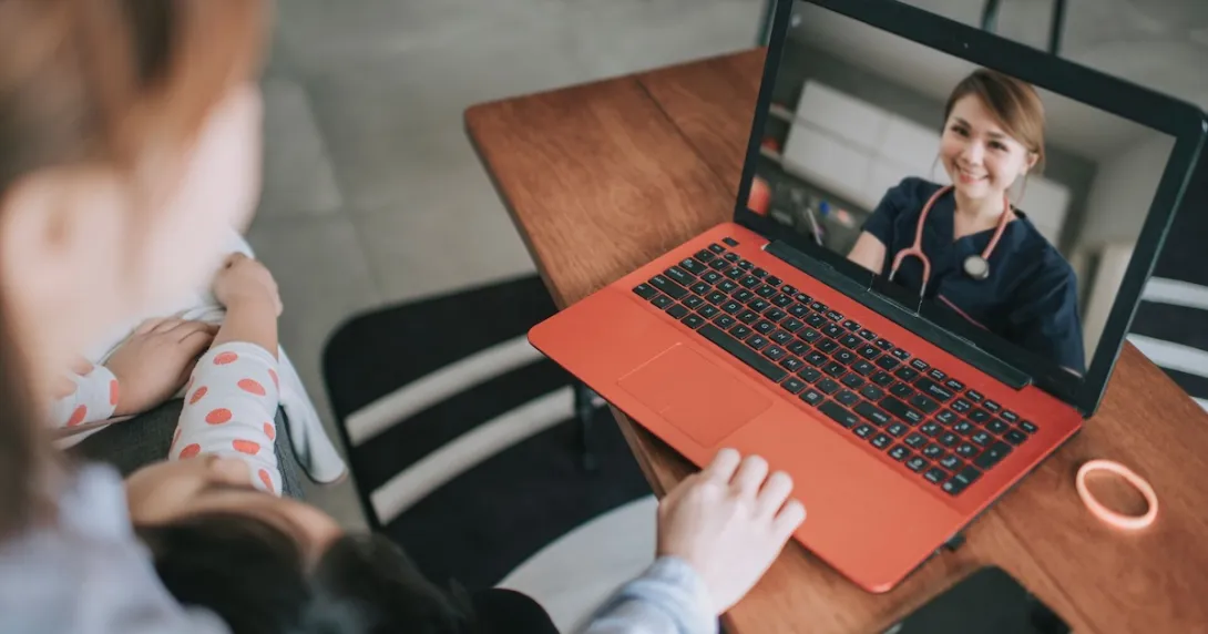 Two people sitting on a couch talking to a telehealth provider Two people sitting on a couch talking to a telehealth provider