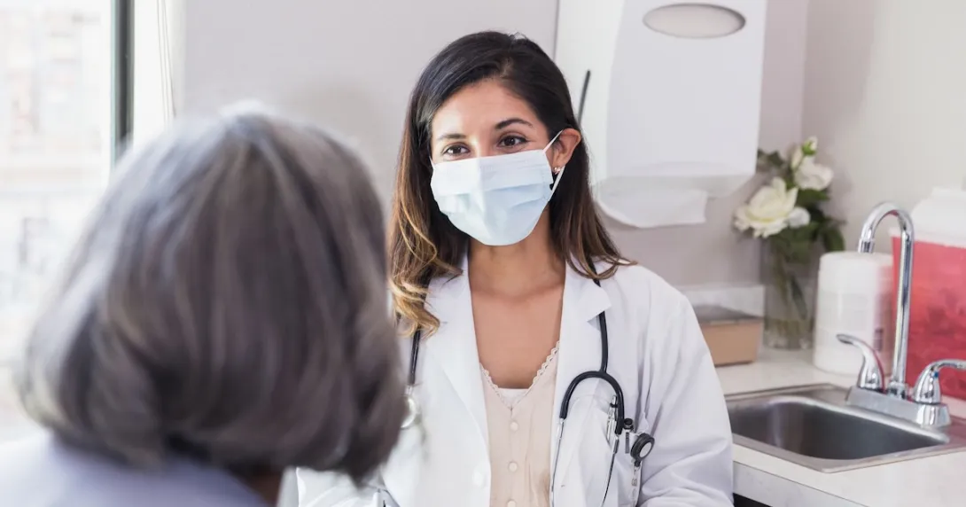 Healthcare provider sitting with a patient in the clinical setting Healthcare provider sitting with a patient in the clinical setting