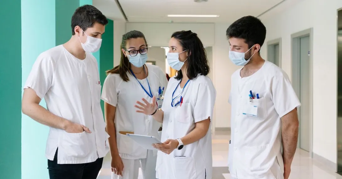 Healthcare workers standing in a hallway talking Healthcare workers standing in a hallway talking