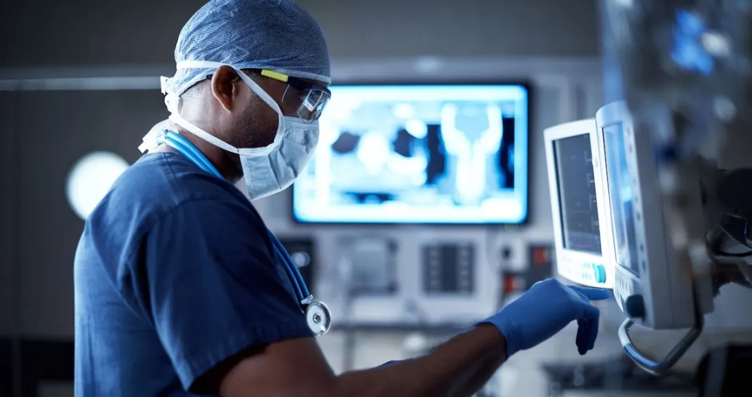 Healthcare provider in scrubs standing in front of an imaging screen Healthcare provider in scrubs standing in front of an imaging screen