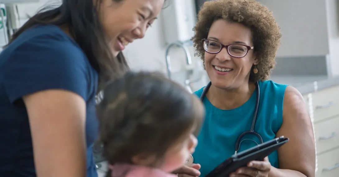 Healthcare provider with a patient and their caregiver Healthcare provider with a patient and their caregiver