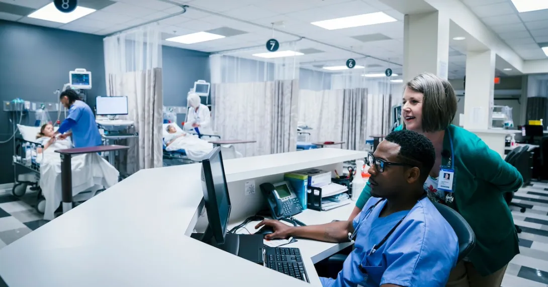 Healthcare providers sitting in a hospital setting Healthcare providers sitting in a hospital setting