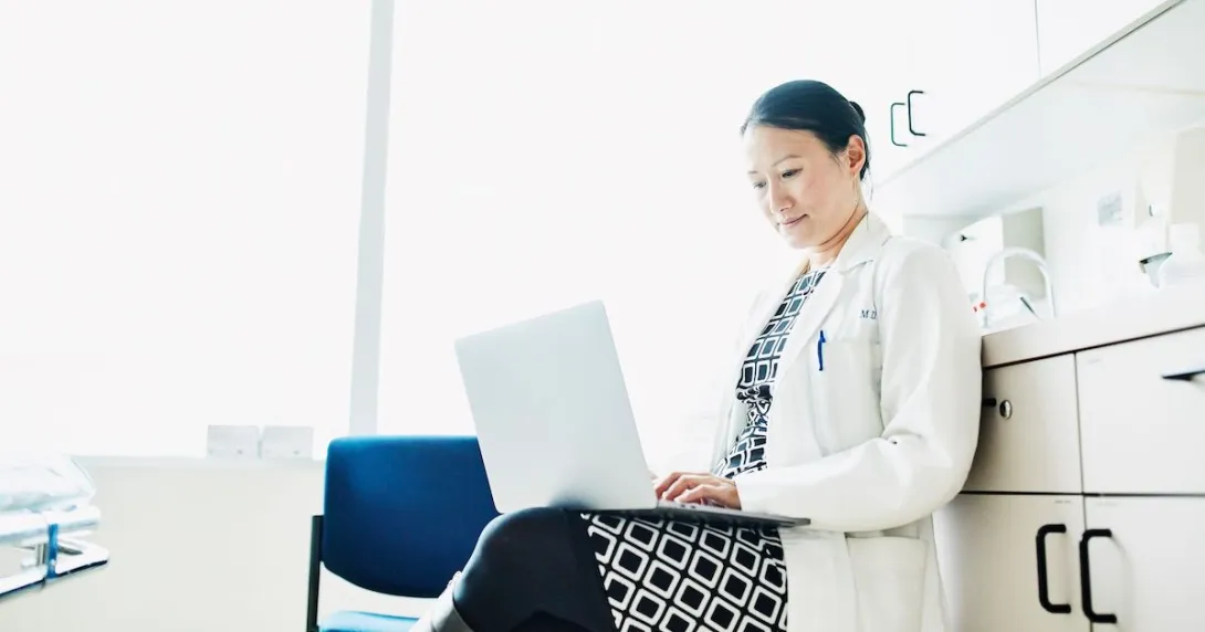 A doctor answering online inquiries on a laptop A doctor answering online inquiries on a laptop