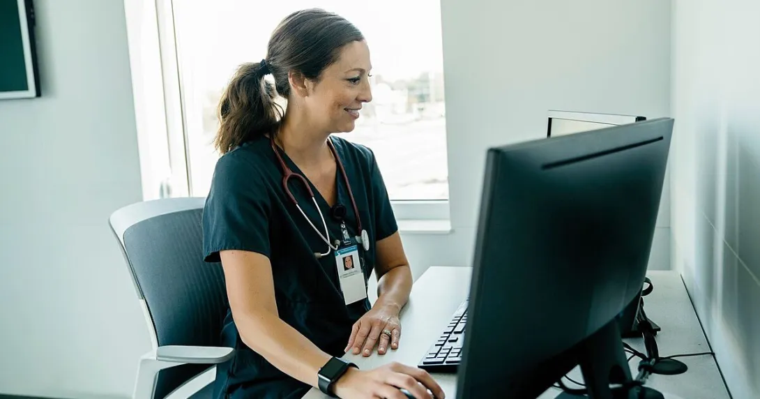 A doctor reviewing a patient's record on a desktop computer A doctor reviewing a patient's record on a desktop computer